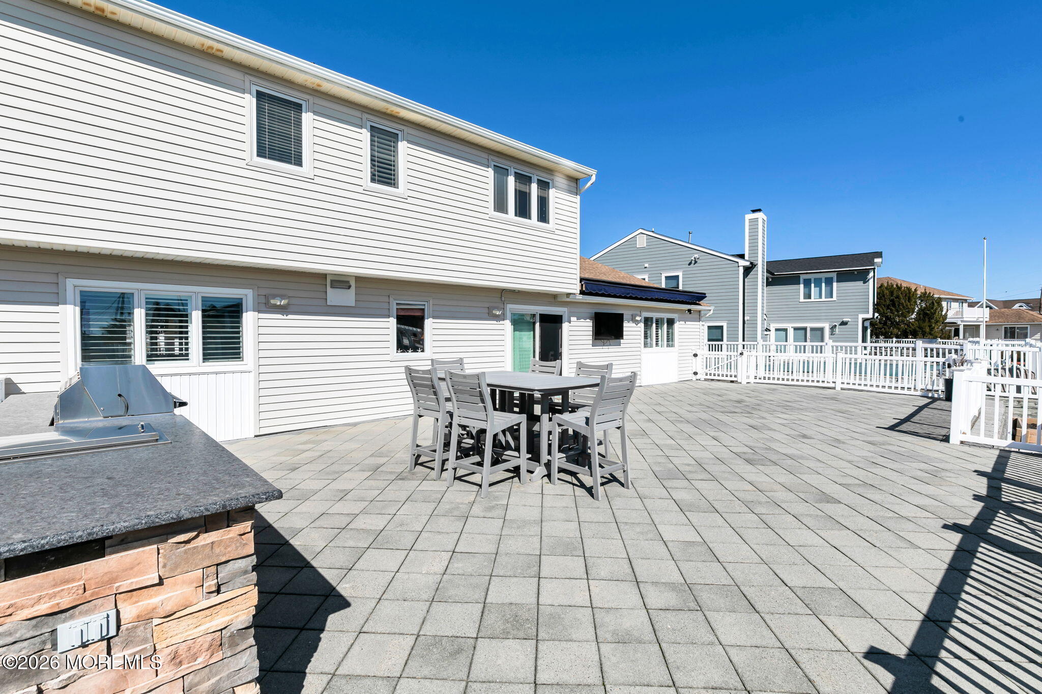 327 Tide Pond Road Mantoloking, NJ 08738 - Photo 34 of 45 a view of a patio with table and chairs with wooden floor and fence