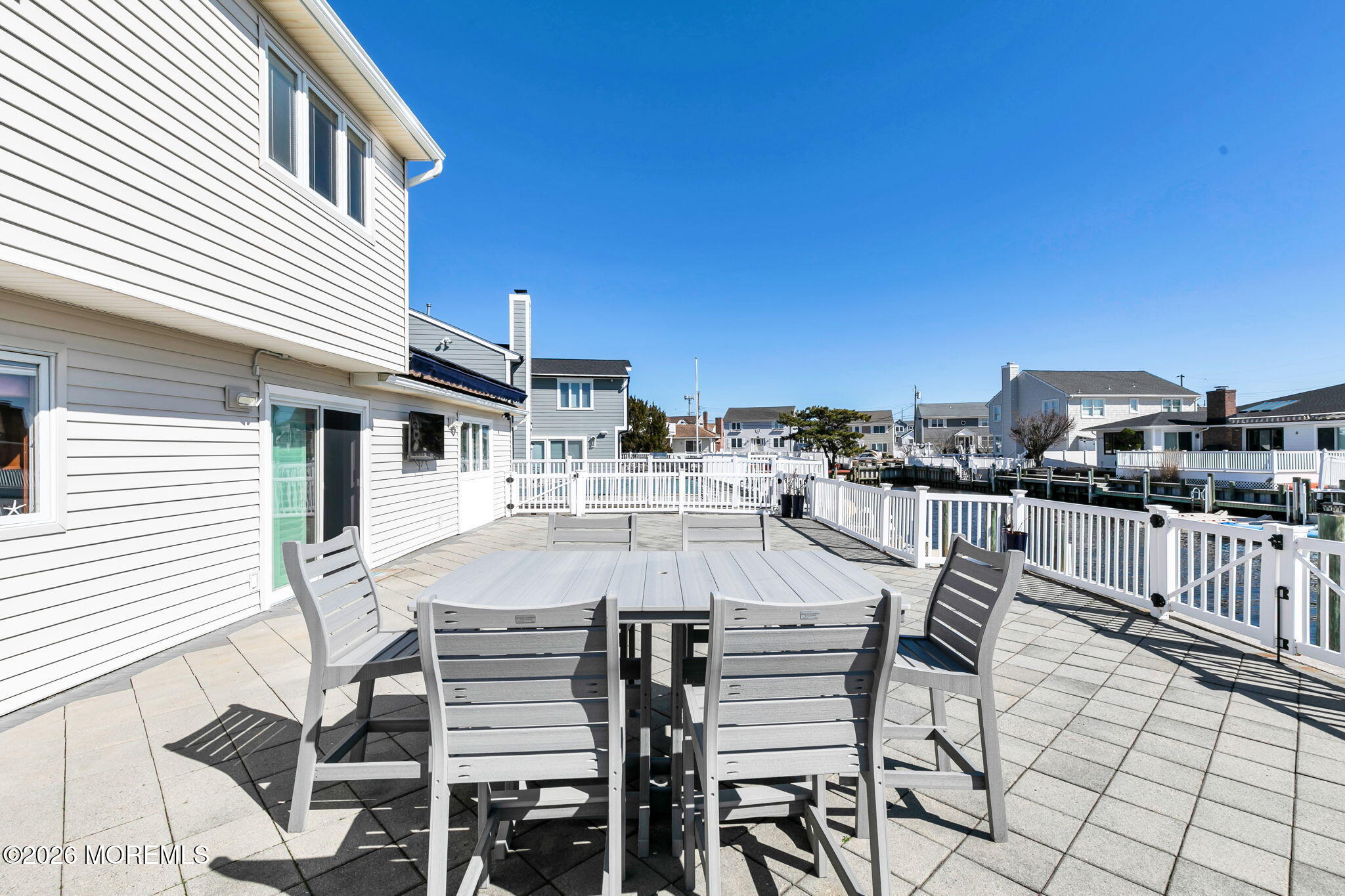 327 Tide Pond Road Mantoloking, NJ 08738 - Photo 37 of 45 a view of a patio with table and chairs with wooden floor and fence