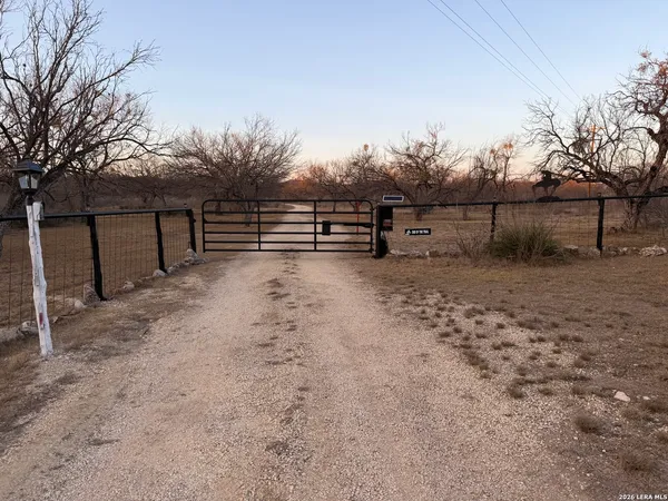 a front view of a house with a garden and trees