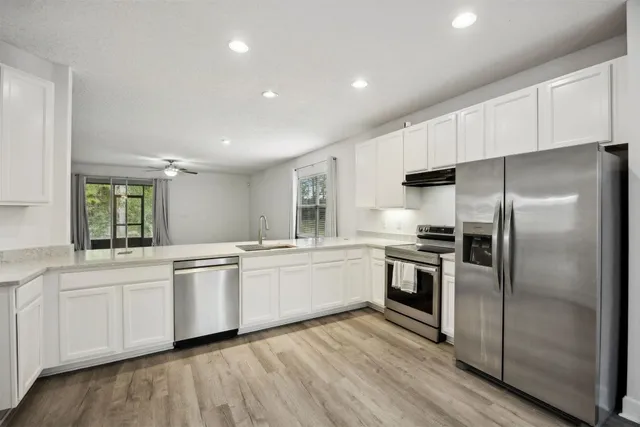 a kitchen with white cabinets and stainless steel appliances