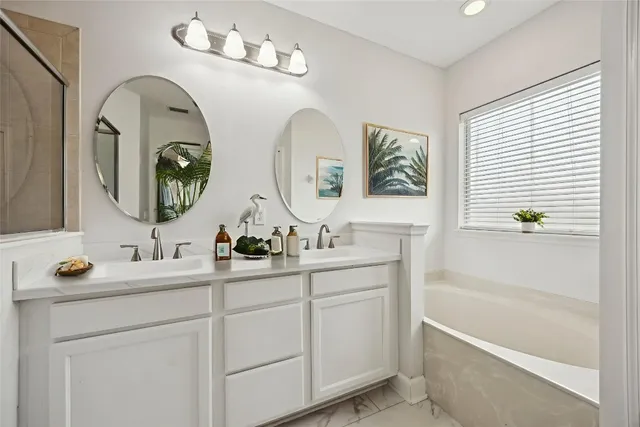 a bathroom with double vanity sinks and a mirror