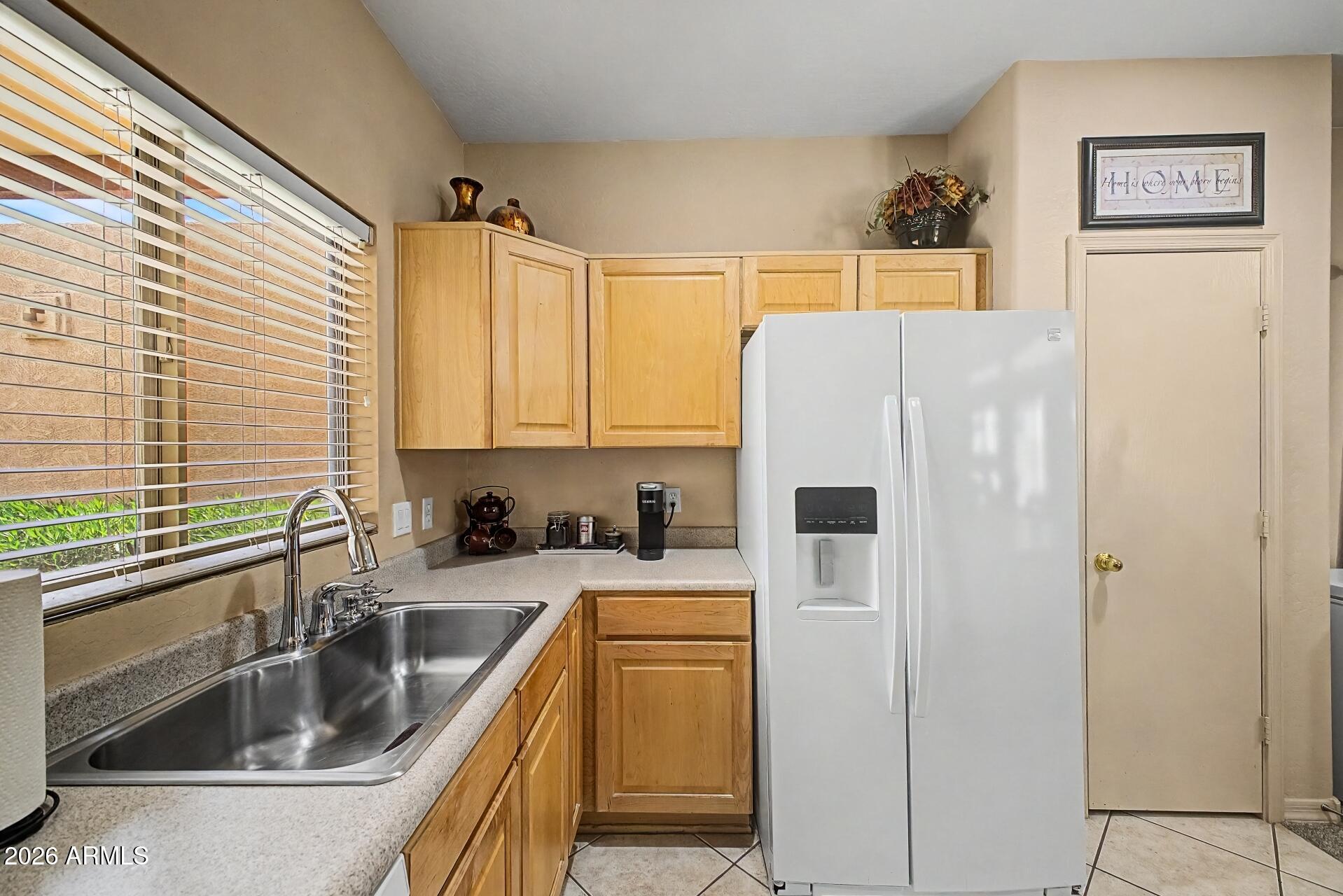 1650 South Crismon Road, Unit 25 Mesa, AZ 85209 - Photo 13 of 33 a kitchen with a refrigerator a sink and cabinets