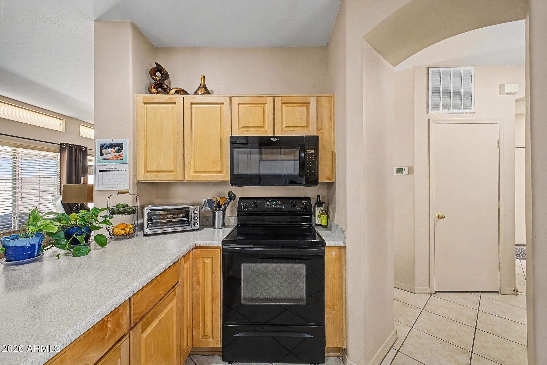 1650 South Crismon Road, Unit 25 Mesa, AZ 85209 - Photo 14 of 33 a kitchen with granite countertop a stove a sink and a microwave