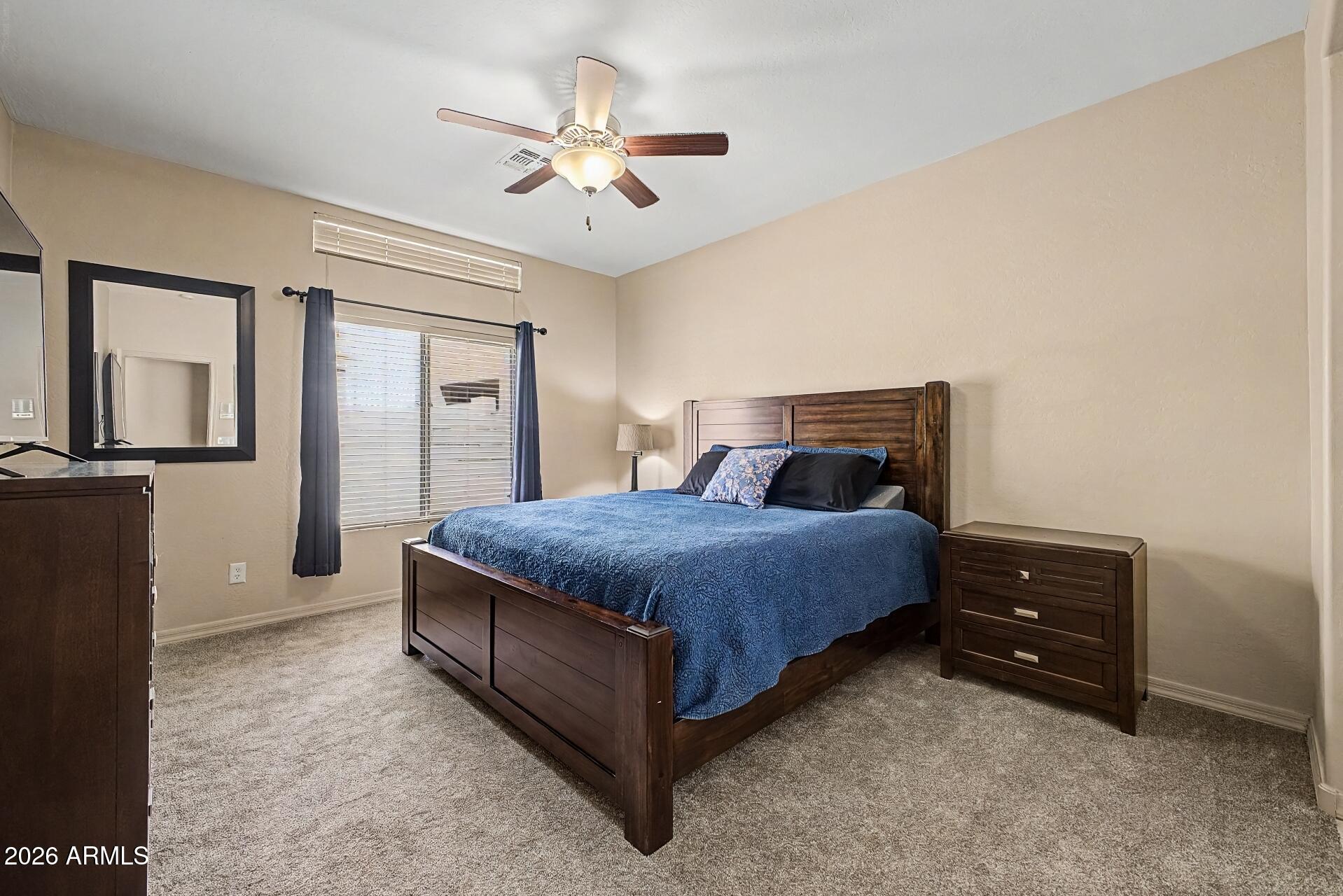 1650 South Crismon Road, Unit 25 Mesa, AZ 85209 - Photo 16 of 33 a bedroom with a bed and a chandelier