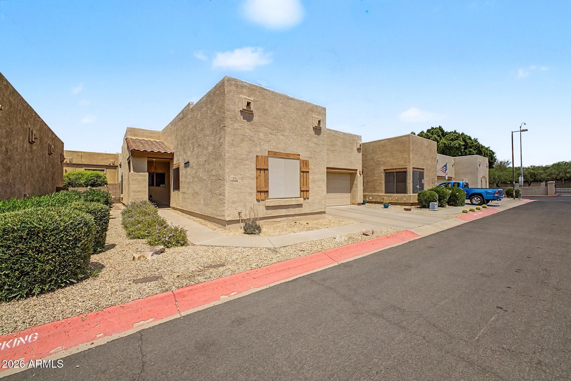 1650 South Crismon Road, Unit 25 Mesa, AZ 85209 - Photo 2 of 33 a front view of a house with a road