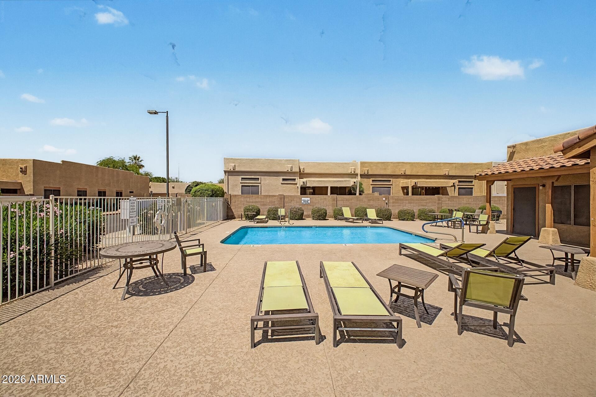 1650 South Crismon Road, Unit 25 Mesa, AZ 85209 - Photo 30 of 33 a view of a swimming pool with a lounge chair