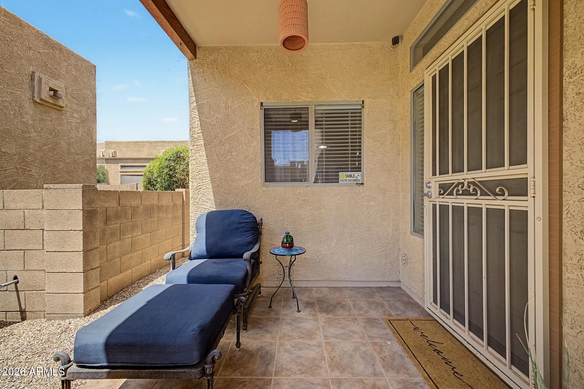 1650 South Crismon Road, Unit 25 Mesa, AZ 85209 - Photo 4 of 33 a view of a balcony with chair and wooden floor