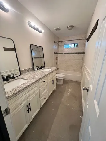 a bathroom with a granite countertop sink mirror and toilet