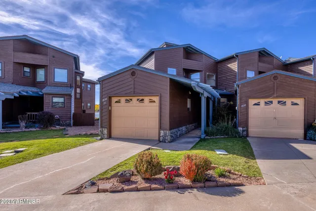 a view of a brick house with a yard and large tree