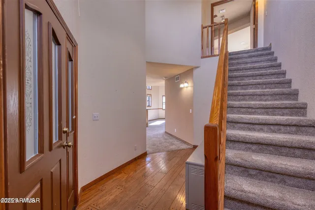 a view of a hallway with wooden floor and entryway