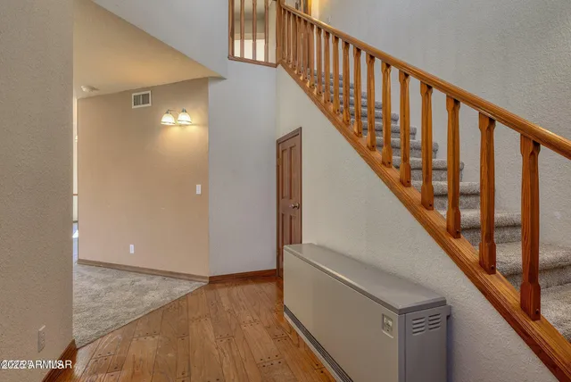 a view of staircase with wooden floor and white walls