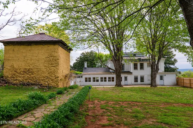a yellow house sitting in middle of the green field
