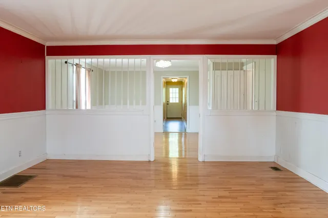 a view of hallway with window and wooden floor