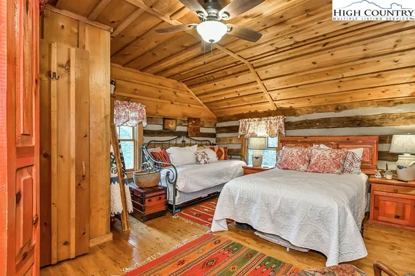 a bedroom with two beds and next to a window