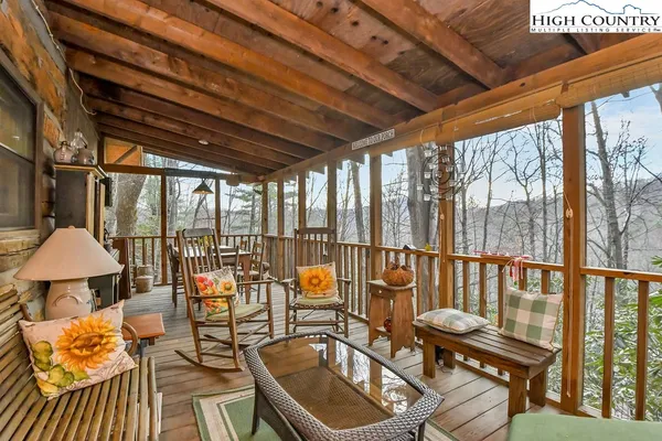 a balcony with chairs and table in wooden floor