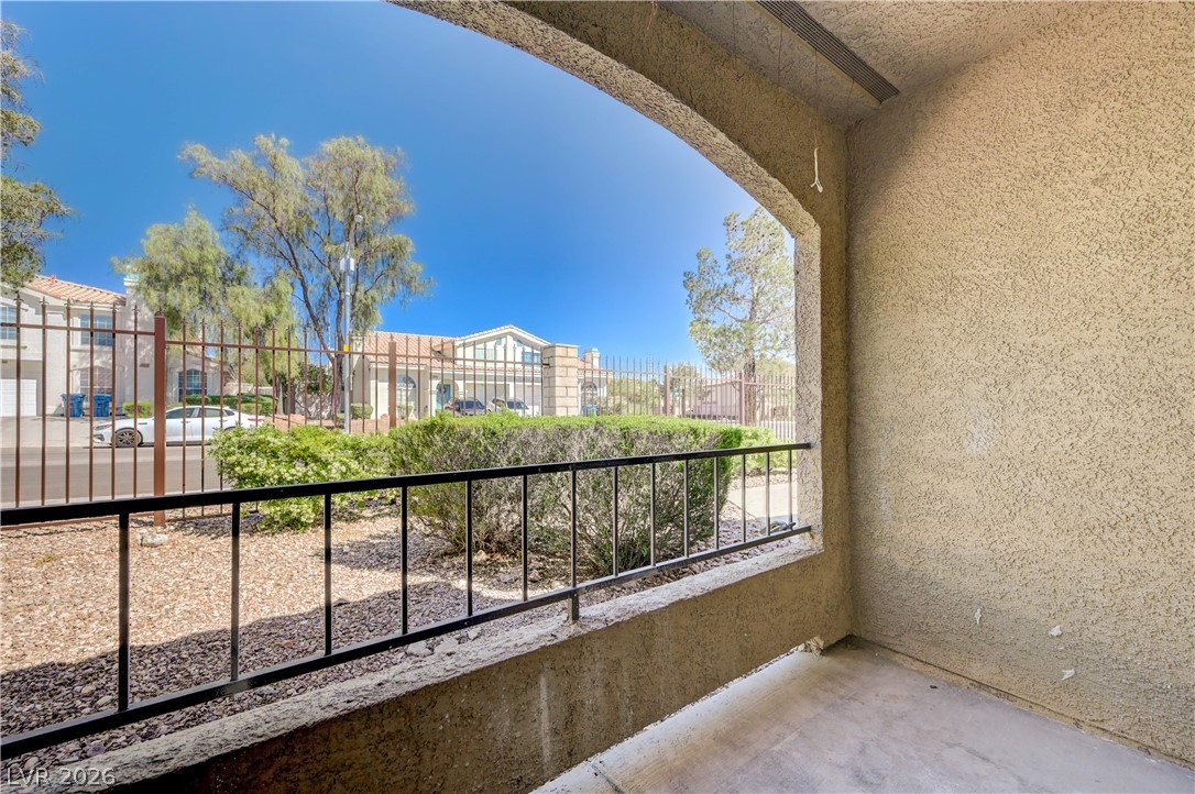 7885 West Flamingo Road, Unit 1050 Las Vegas, NV 89147 - Photo 33 of 62 A private covered patio overlooks a landscaped common area with mature trees and neighborhood views.