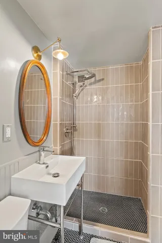 a bathroom with a sink a mirror and a shower