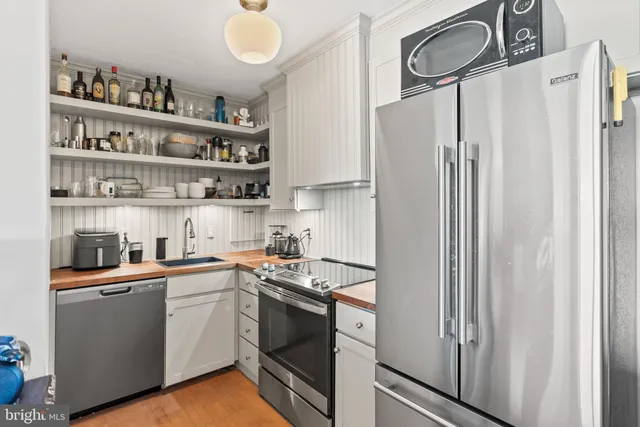 a kitchen with stainless steel appliances a refrigerator sink and cabinets