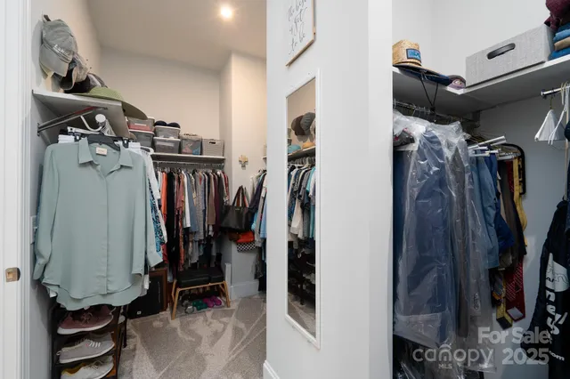a view of walk in closet with clothes and shoes