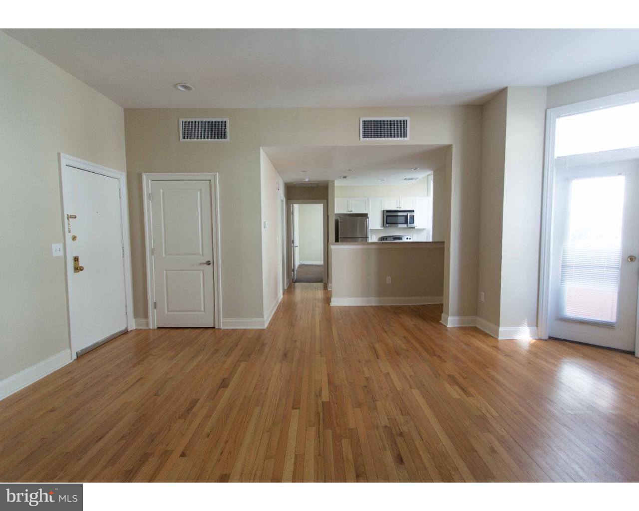 1100 Spruce Street, Unit 2B Philadelphia, PA 19107 - Photo 2 of 22 a view of empty room with wooden floor and kitchen view