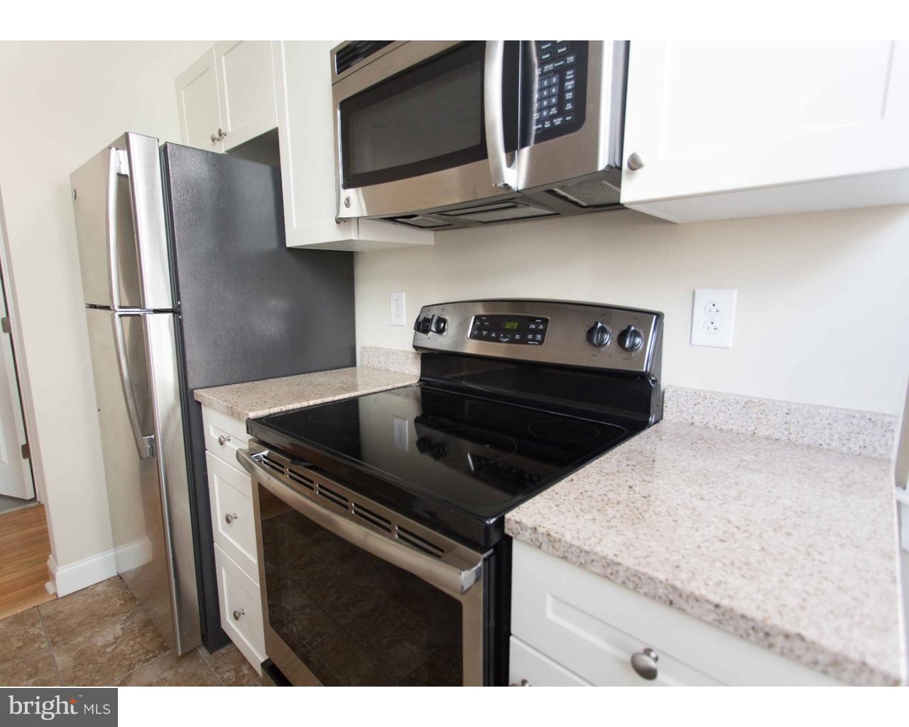 1100 Spruce Street, Unit 2B Philadelphia, PA 19107 - Photo 9 of 22 a kitchen with stainless steel appliances granite countertop a stove microwave and refrigerator