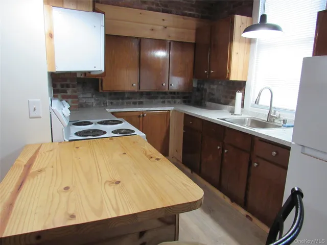 a kitchen with a stove a sink and cabinets