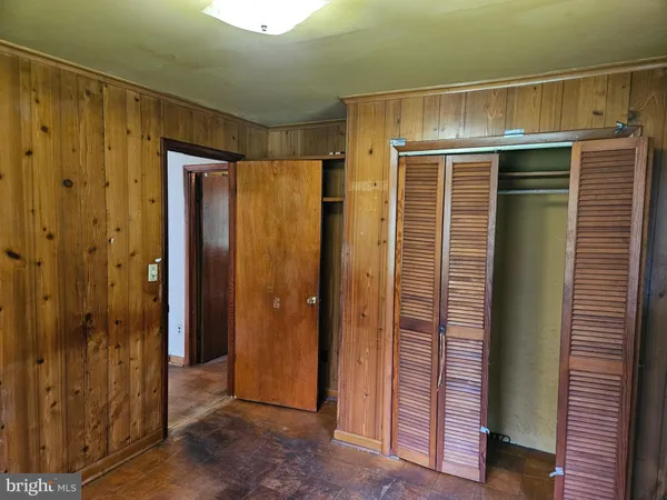 a bathroom with a glass door shower and closet
