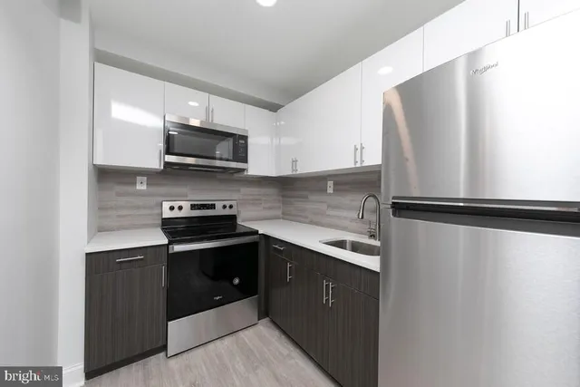 a kitchen with stainless steel appliances white cabinets and a stove top oven