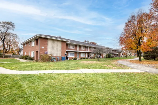 a view of a house with a big yard and large trees