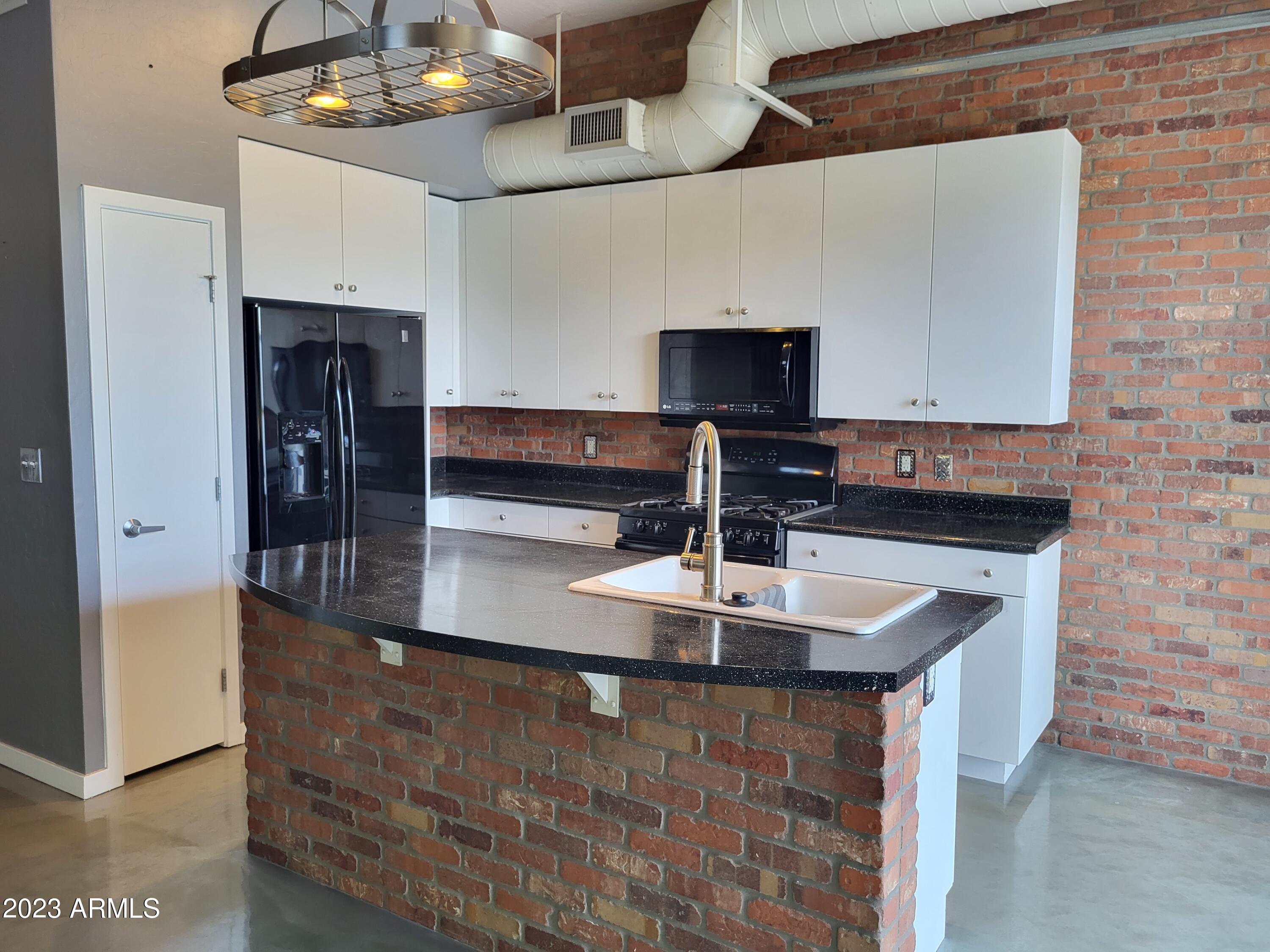 914 East Osborn Road, Unit 218 Phoenix, AZ 85014 - Photo 5 of 30 a kitchen with stainless steel appliances granite countertop a sink and a microwave