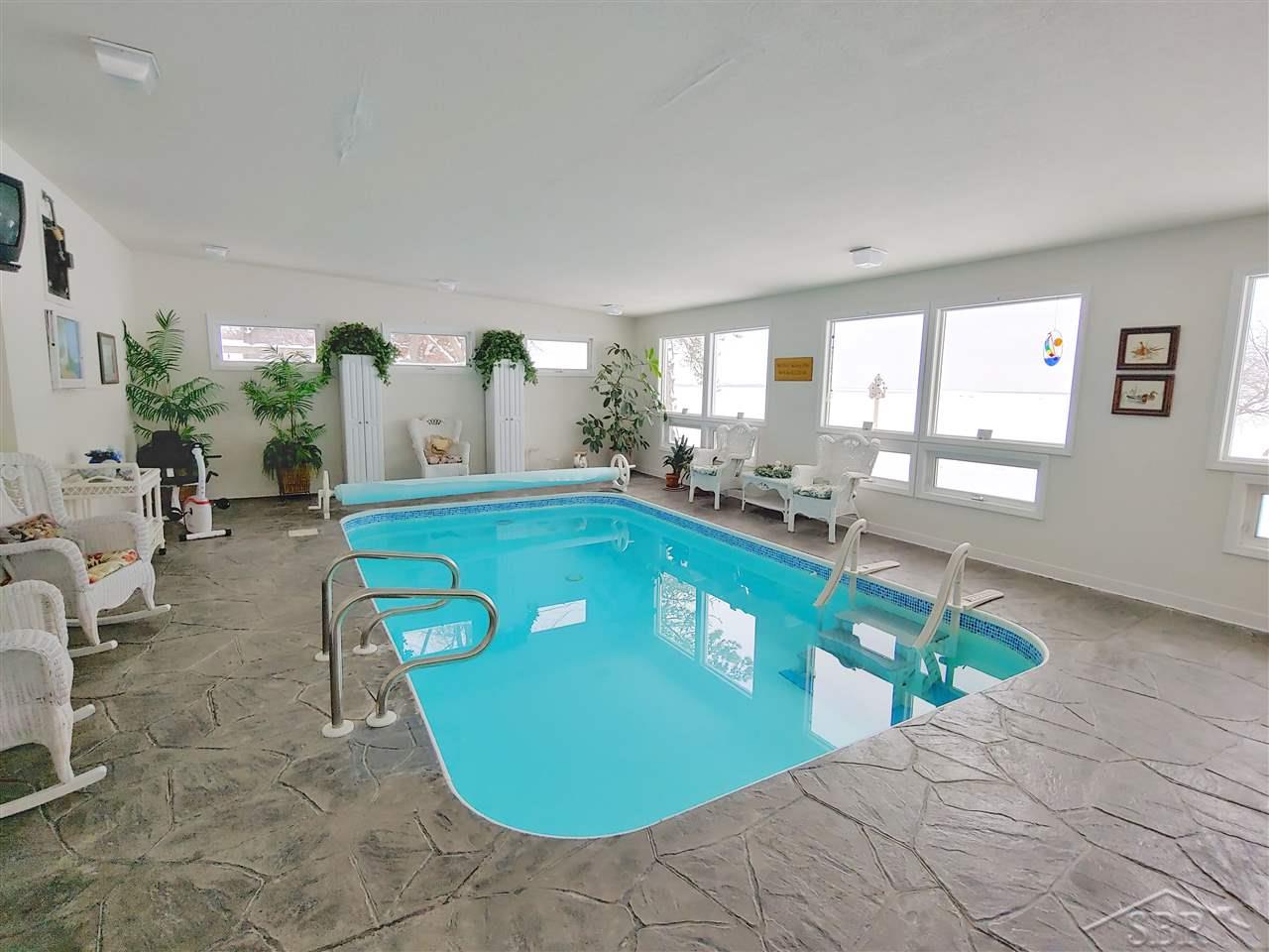 156 North Linwood Beach Road Linwood, MI 48634 - Photo 57 of 81 Heated pool, heated floors and a spectacular view of the lake, you may never leave this room.