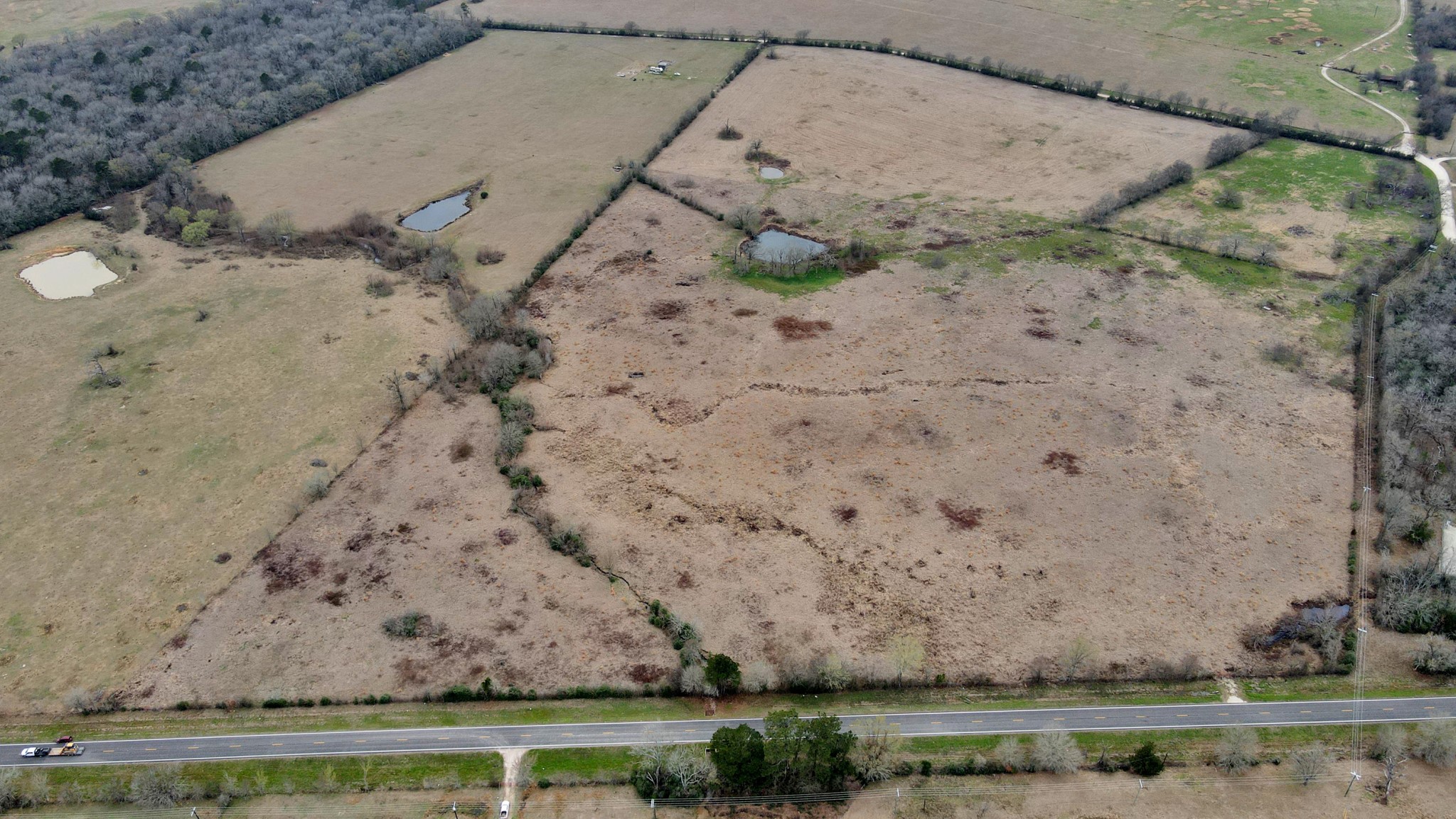 a view of a dry yard with wooden fence