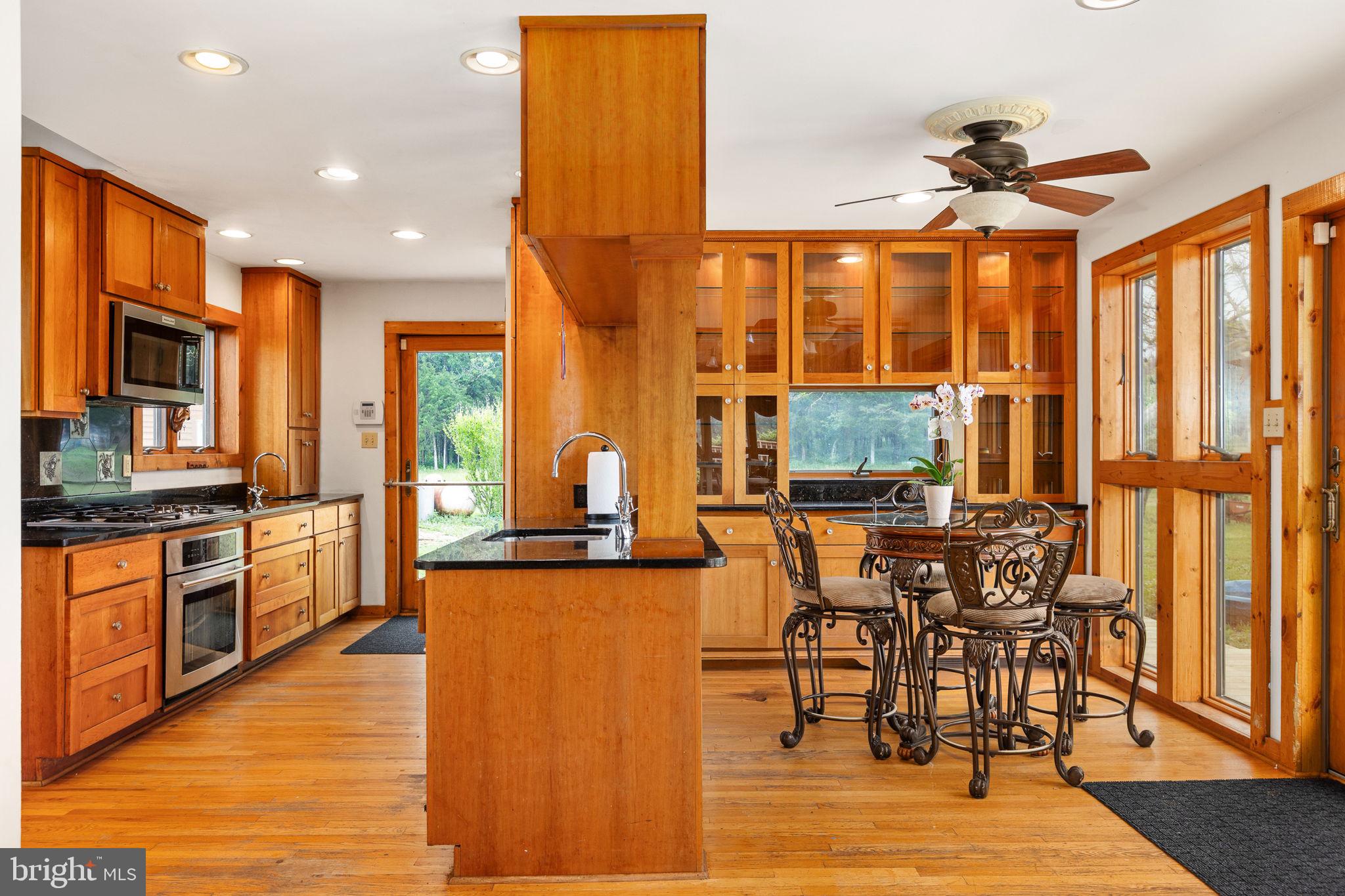 6119 Beach Road Midland, VA 22728 - Photo 32 of 98 a kitchen with stainless steel appliances granite countertop wooden floor a dining table and chairs