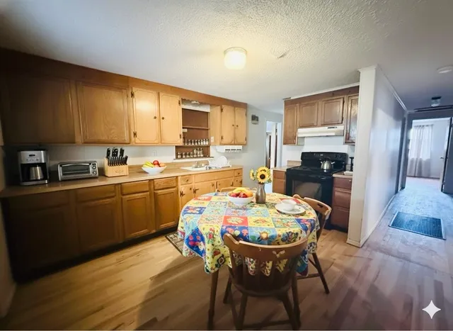 a kitchen with a dining table chairs refrigerator and cabinets