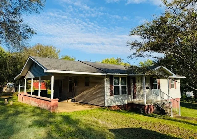 a view of a house with a yard and sitting area