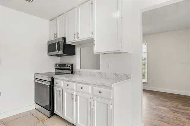 a kitchen with stainless steel appliances granite countertop a sink and a white stove