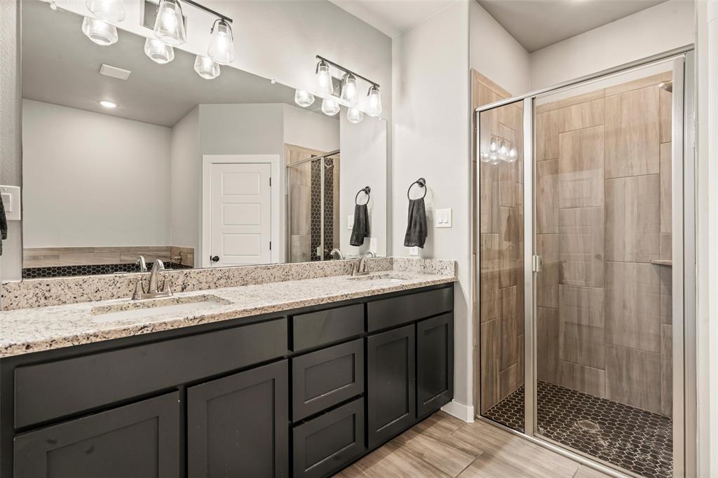 1034 Antelope Trail Temple, TX 76504 - Photo 13 of 24 a bathroom with a granite countertop sink a mirror and a shower