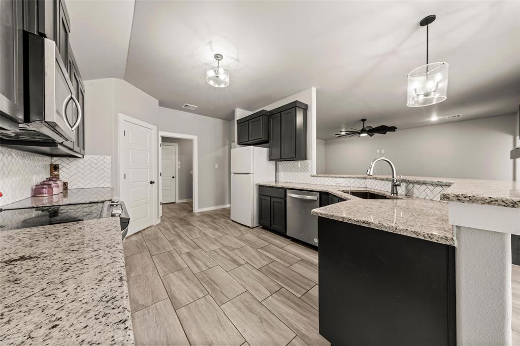 1034 Antelope Trail Temple, TX 76504 - Photo 7 of 24 a kitchen with granite countertop a sink stainless steel appliances and cabinets