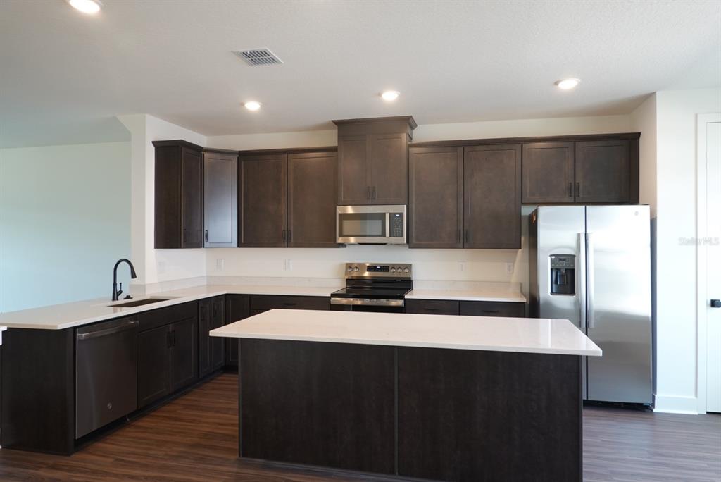15250 Groveside Road Winter Garden, FL 34787 - Photo 5 of 15 a kitchen with kitchen island a sink stainless steel appliances and cabinets