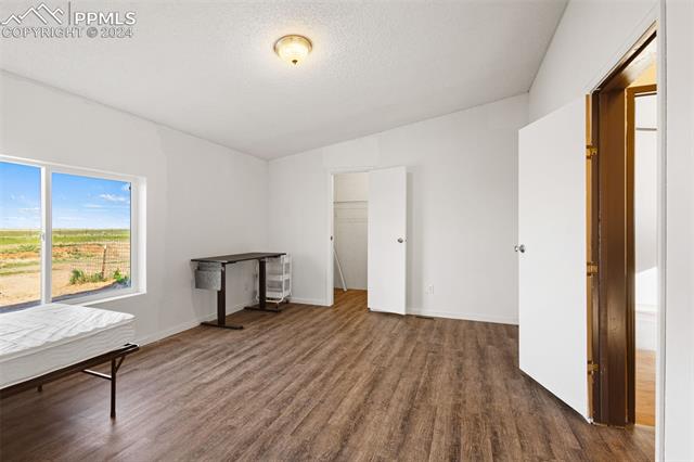 36015 Corona Road Yoder, CO 80864 - Photo 9 of 27 Bedroom with a textured ceiling and dark hardwood / wood-style flooring