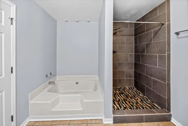 a spacious bathroom with a granite countertop sink a mirror and a shower