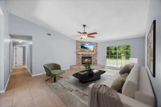 a living room with furniture a fireplace and a large window