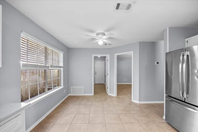 a kitchen with a refrigerator and white cabinets