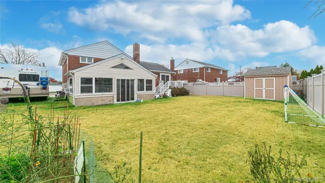 a view of a house with a big yard and large trees