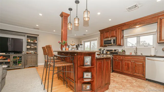 a kitchen with stainless steel appliances granite countertop a sink a stove a dining table and chairs