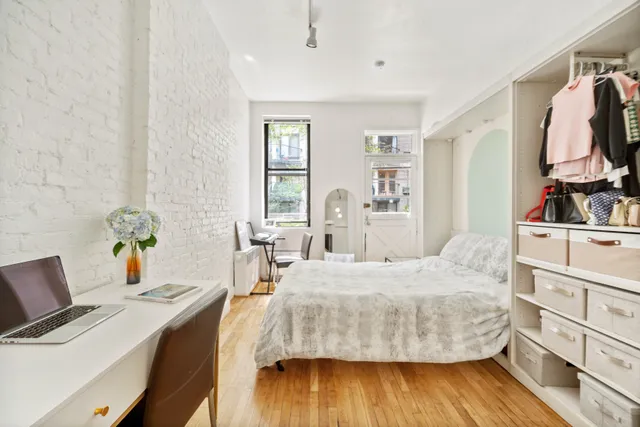 a bedroom with a bed and wooden floor