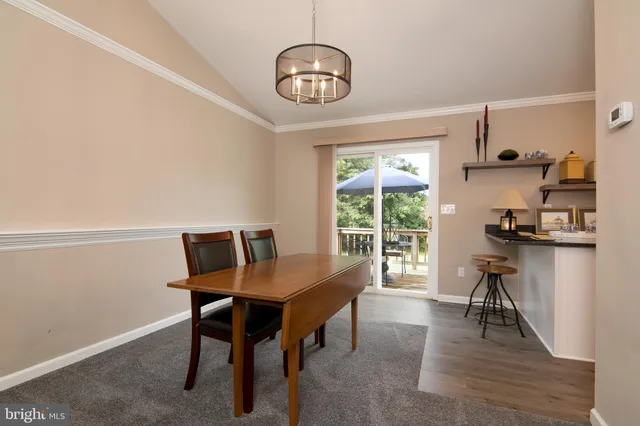 a view of a dining room with furniture and a chandelier
