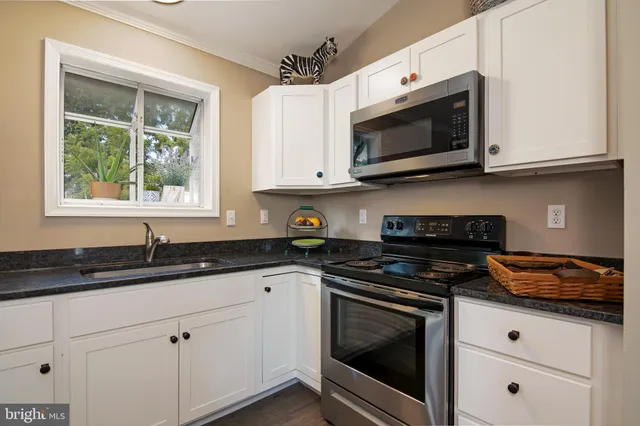 a kitchen with white cabinets stainless steel appliances and sink