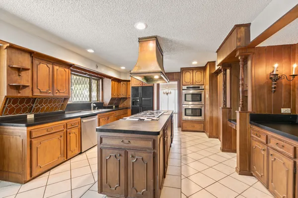 a kitchen with stainless steel appliances kitchen island granite countertop a sink and cabinets