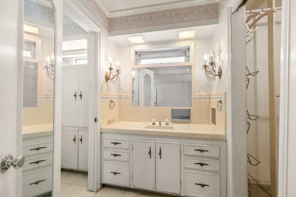 a kitchen with white cabinets and a window